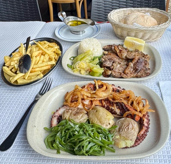 seafood platter with octopus, shrimp, potatoes, and seaweed